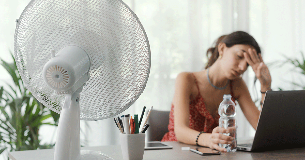 shows a woman trying to cool office with a fan, suggesting they need better hvac design